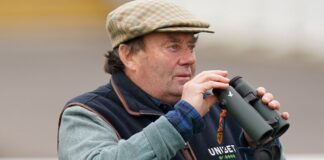 Trainer Nicky Henderson watching horses gallop at Newbury