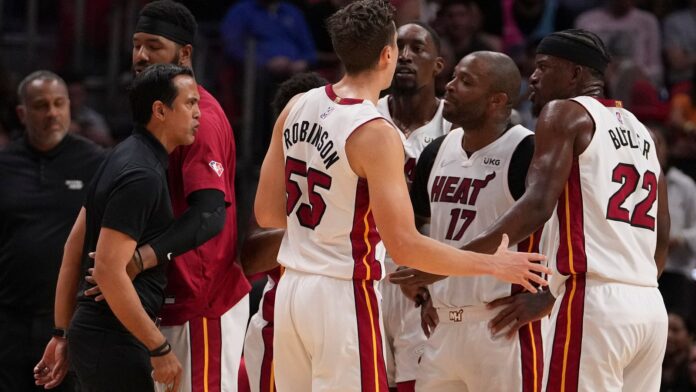 Miami Heat head coach Erik Spoelstra is held back as strong words are exchanged on the Miami Heat bench