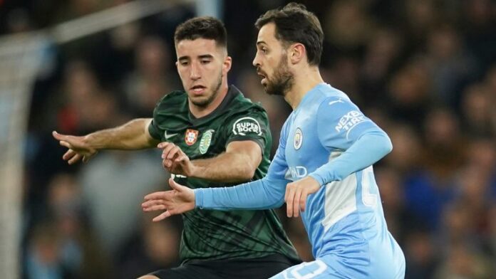 Sporting-finished-Manchester-City-but-qualified-for-the-quarter-finals.jpg Bernardo Silva, Manchester City, right, takes on the Sporting Goncalo Inacio challenge