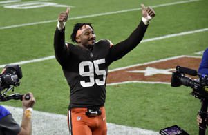 a group of baseball players standing on top of a grass covered field: Myles Garrett #95 of the Cleveland Browns gives a thumbs up as he leaves the field following a win against the Cincinnati Bengals at FirstEnergy Stadium on September 17, 2020 in Cleveland, Ohio. Jason Miller/Getty Images