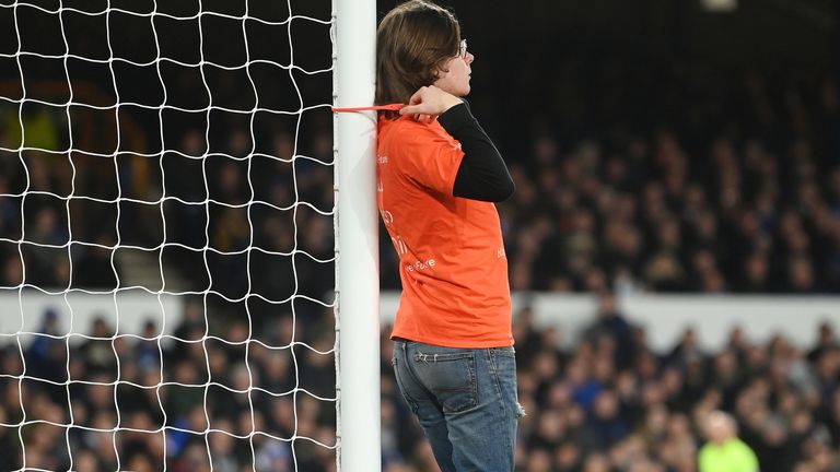 A protester ties himself to a goal post during Everton's match against Newcastle