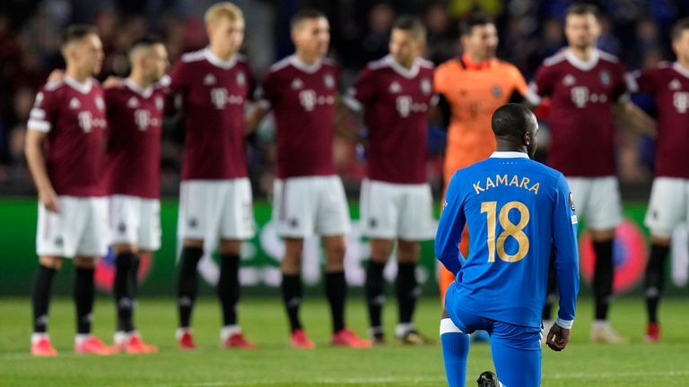 Glenn Camara takes a knee in front of the Sparta Prague players